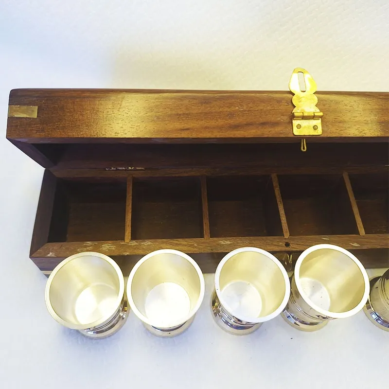 Bronze shot glasses in a wooden box